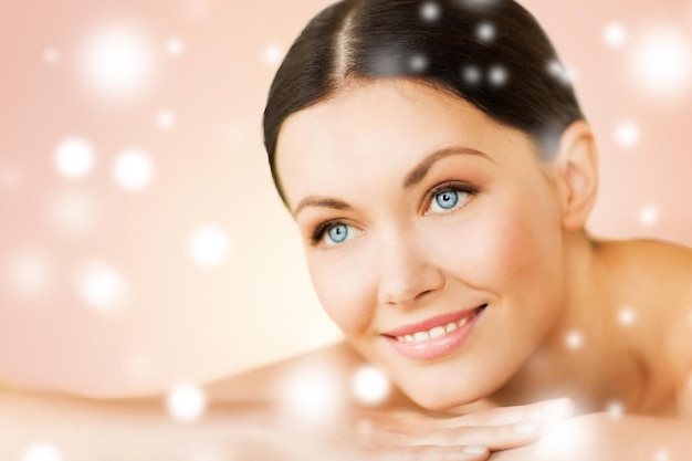 health and beauty concept - woman in spa salon lying on the massage desk