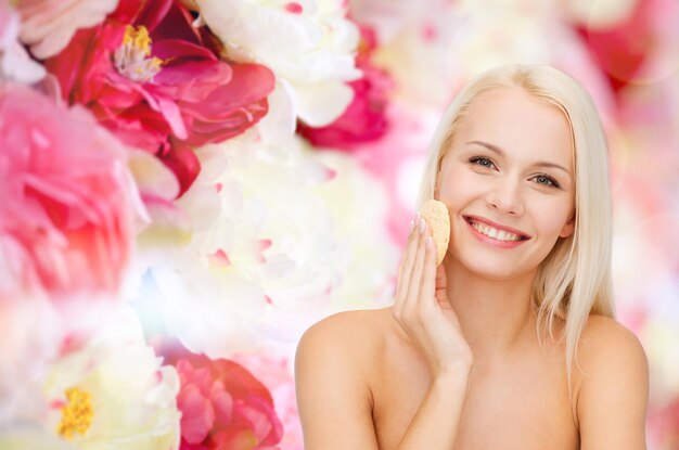 health, beauty and spa concept - beautiful woman with sponge