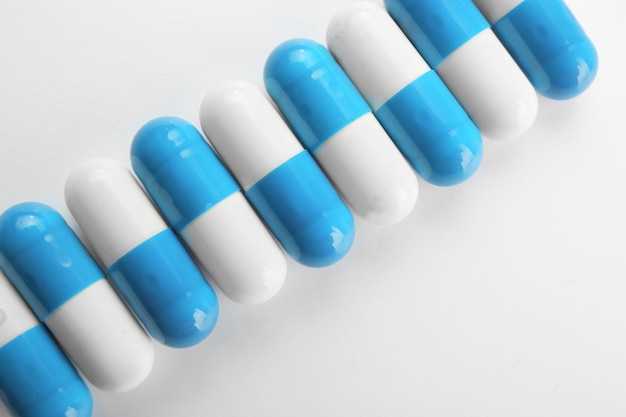 Foto concetto di assistenza sanitaria pillole colorate su sfondo bianco
