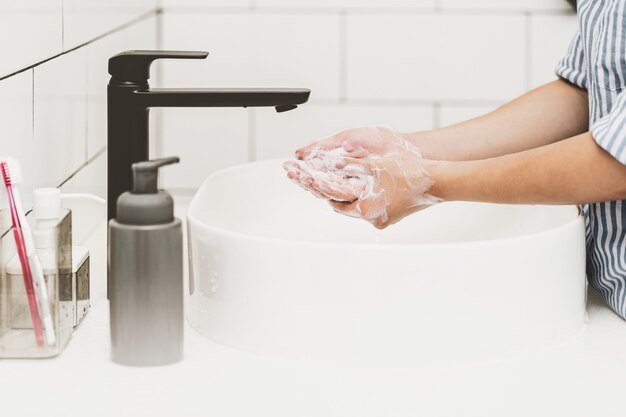 Covid19パンデミックコンセプトクローズアップのヘルスケア水道水でアジアの手洗い