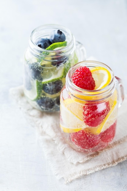 Health care fitness healthy nutrition diet concept Fresh cool lemon lime berries raspberry blueberry infused water cocktail detox drink lemonade for spring summer days