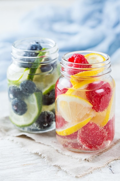 Health care fitness healthy nutrition diet concept Fresh cool lemon lime berries raspberry blueberry infused water cocktail detox drink lemonade for spring summer days