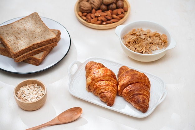 Colazione salutare e colorata: cialde, muffin, mandorle, nocciole, frutta fresca varia sul tavolo. concetto di salute alimentare. vista dall'alto.