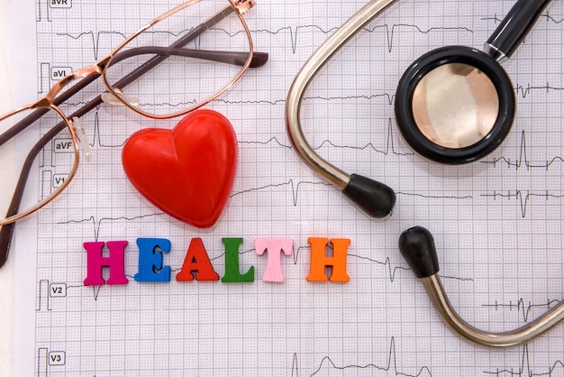 Health concept, red heart with stethoscope on cardiogram