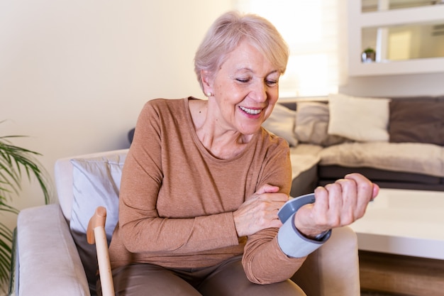 Health concept senior women is taking care for health with blood pressure monitors. High blood pressure. Mature woman measuring blood pressure at home