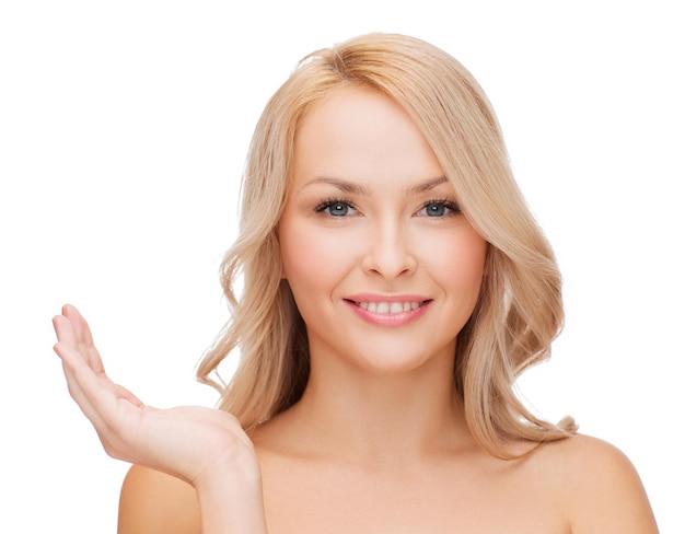 health, cosmetics, advertising and beauty concept - smiling woman holding something imaginary