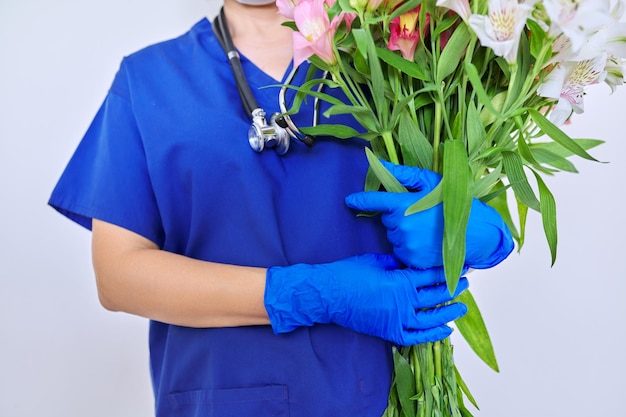 医師の看護師の手に花の健康の日のクローズアップ花束