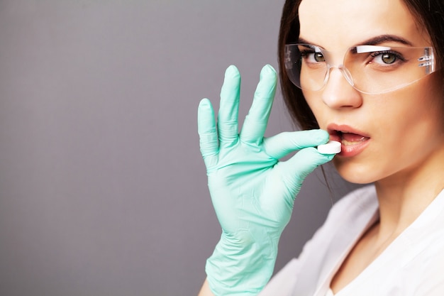 health, a doctor in a white coat holding a pill