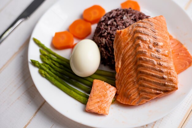 Health food concept, salmon with rice and vegetable on wood background 