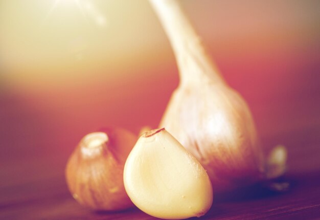 Foto salute, cibo, cucina, medicina tradizionale e concetto etnoscientifico - primo piano di aglio su tavola di legno