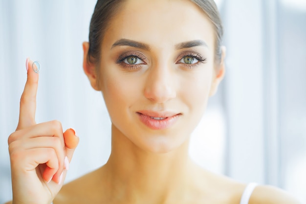 Health. Happy Woman with Contact Lenses on the Finger. Eye Care.