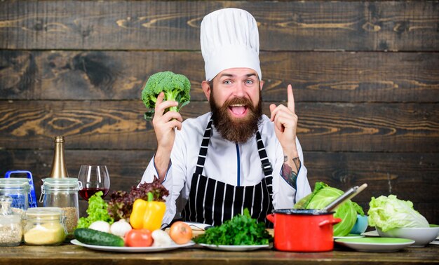 Health in his hands Cuisine culinary Vitamin Dieting organic food Happy bearded man chef recipe Healthy food cooking Mature hipster with beard Vegetarian salad with fresh vegetables