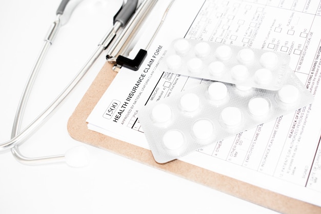 건강 보험 청구 양식. 청진기와 흰색 알약으로 개별 의료 건강 보험 정책