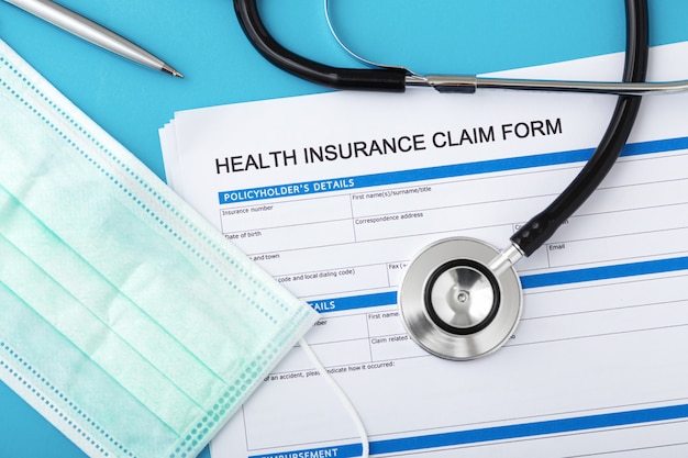 Health insurance claim form with stethoscope and surgical mask