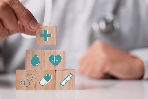 health insurance concept, doctor holding wood cube with medical icon