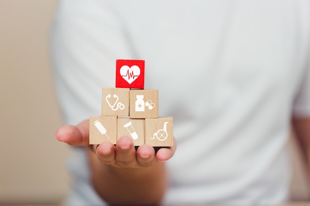 Photo health insurance concept,  hand arranging wood block stacking with icon healthcare medical