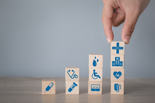 health insurance concept,hand arranging wood block stacking with icon healthcare medical.