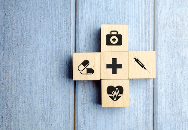 Health insurance concept wooden blocks with healthcare medical icon blue background