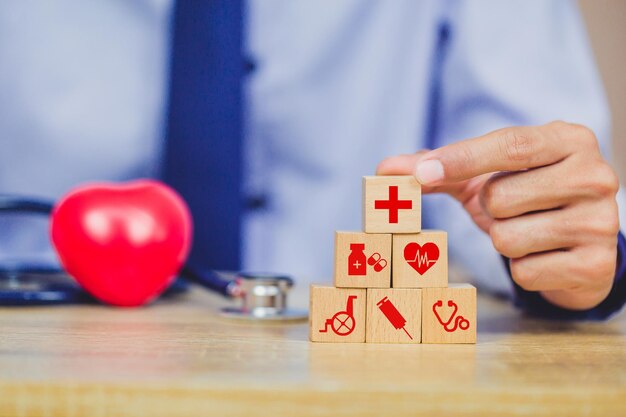 Health insurance concepthand arranging wood block stacking with icon healthcare medical