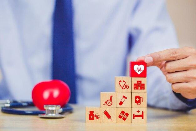 Foto concept di assicurazione sanitaria e organizzazione dell'impilamento di blocchi di legno con icona sanitaria medica