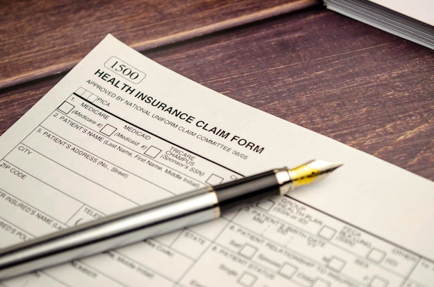 Health insurance form with pen on wooden background