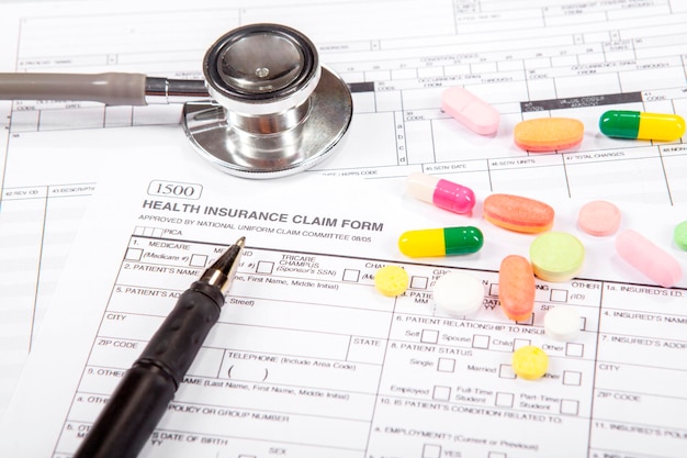 Health insurance form with stethoscope and drugs