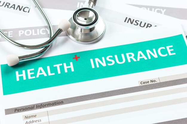 Photo health insurance form with stethoscope in top view