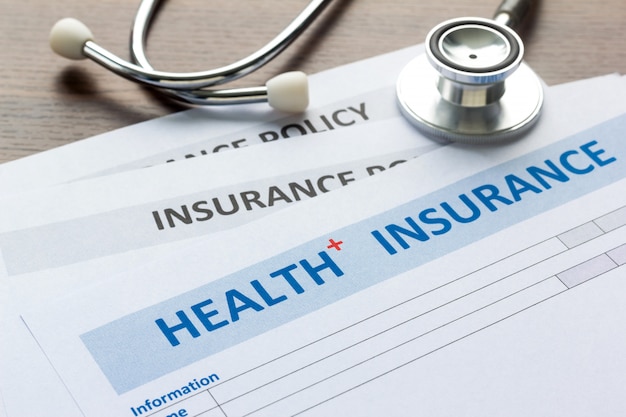 Photo health insurance form with stethoscope in top view