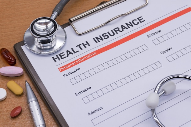 Health insurance paperwork, medicine, stethoscope. Health insurance claim concept.