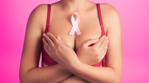 Salute, medicina, concetto di bellezza - reggiseno rad donna nuda con nastro rosa di consapevolezza del cancro al seno. supporto ai pazienti con oncologia. sfondo ravvicinato