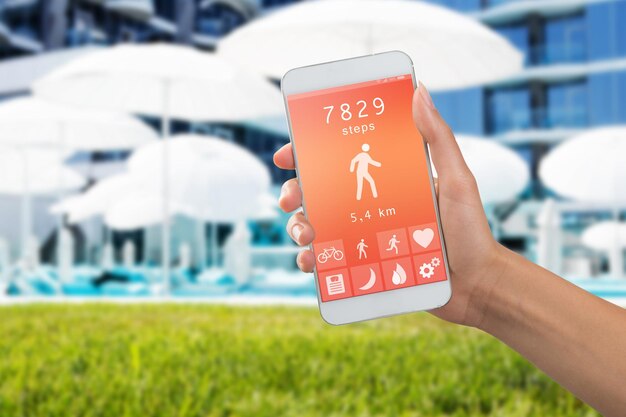 Концепция мониторинга здоровья специальное приложение на смартфоне в руке на фоне ландшафта на открытом воздухе