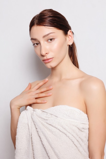 Photo health, people and beauty concept - beautiful woman in white bathrobe after spa. photo of well-groomed woman on white background. wellness and spa concept.