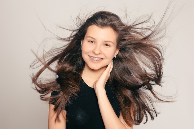 Health, people, dentist and lifestyle concept - Portrait of teen girl showing dental braces. candid portrait of a girl wearing braces, with hair motion. laughing girl wearing braces, cheerful portrait