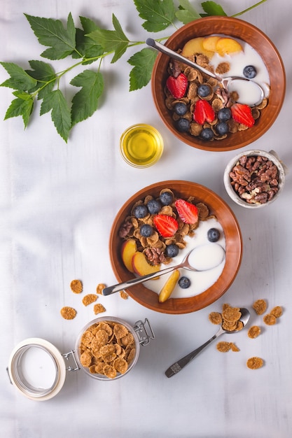 Health plate cereal with strawberries and yogurt on a white tablecloth