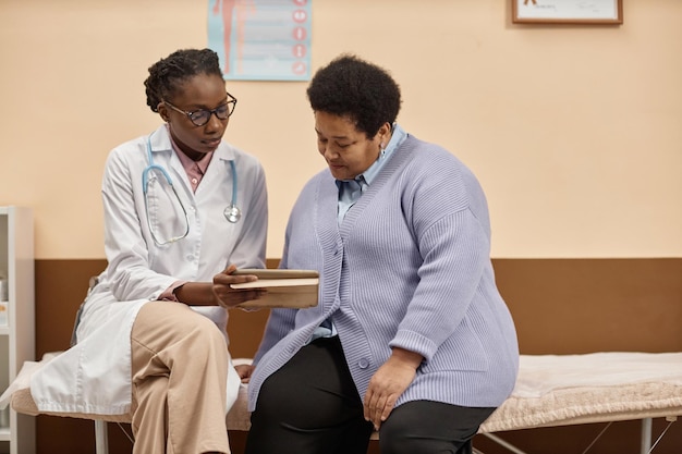health practitioner showing lab report to patient on tablet