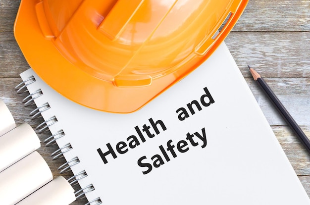 Photo health and safety with orange helmetpencil and notebooks