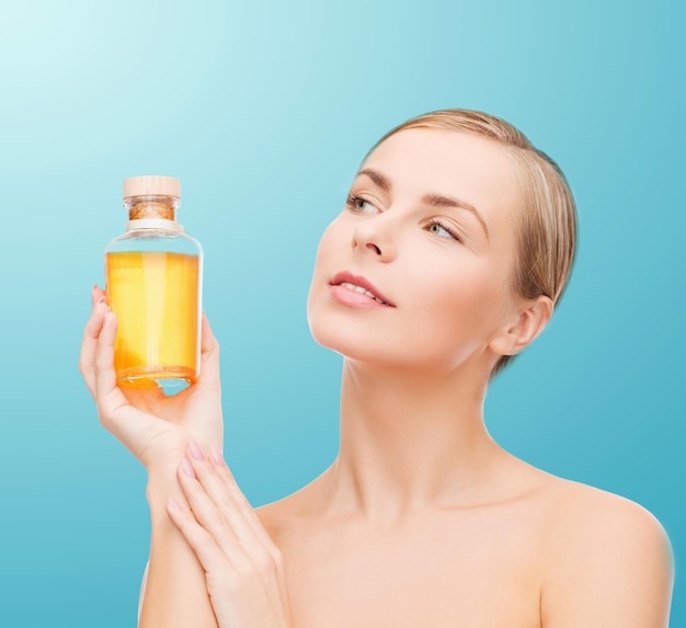 health, spa and beauty concept - lovely woman with oil bottle