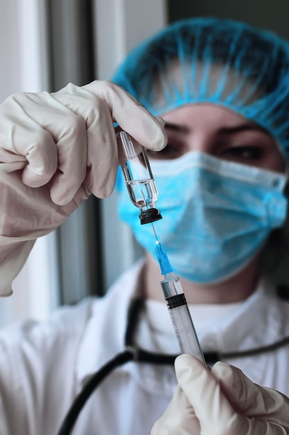 Health worker dials the vaccine into a syringe