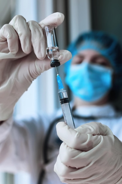 医療従事者はワクチンを注射器にダイヤルします