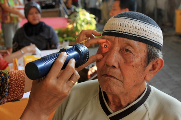 health workers are checking the patient's eyes. 