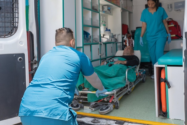 Health workers taking a patient out of an ambulance