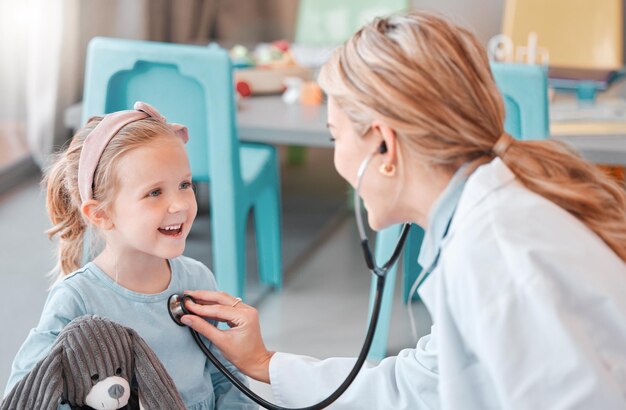 healthcare child and doctor for checkup with stethoscope wellness and health for sound with smile hospital female pediatrician and girl for medical exam heart rhythm and respiratory wellbeing