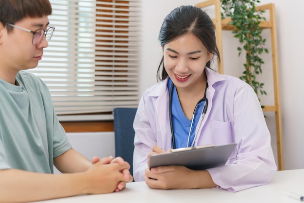 Healthcare concept Female doctor give advice and writing prescription to patient in clinic