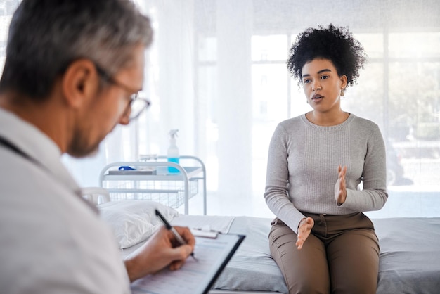 Healthcare consulting and insurance with a black woman patient sitting in a hospital with her doctor Medical consultant and insurance with a female talking to a medicine professional for diagnosis