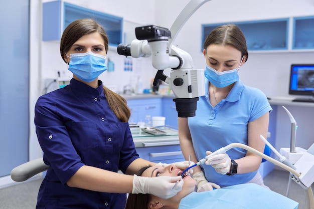 의료 치과 의학, 여자 의사 치과 의사는 치과 현미경과 도구를 사용하여 치아를 치료합니다. 전문 현대 치과 장비