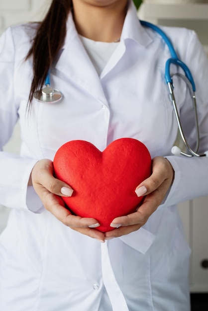 Foto concept di assicurazione sanitaria medico o scienziato donna con un grande cuore rosso in mano