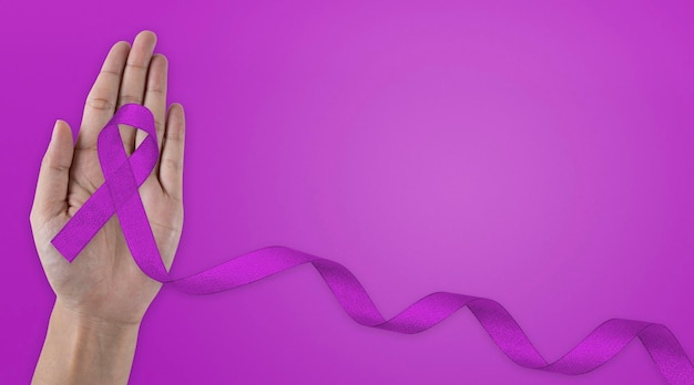 Foto concetto di assicurazione sanitaria mani che tengono nastro viola o viola su tessuto bianco con spazio per la copia cancro pancreatico consapevolezza del cancro ai testicoli