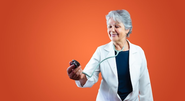 ヘルスケア - オレンジに分離された聴診器でブラジルの成熟した医師や獣医の女性