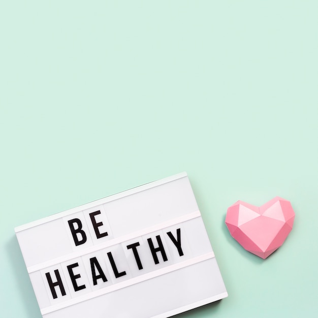 Healthcare and medical concept. Lightbox with words Be Healthy and pink paper heart