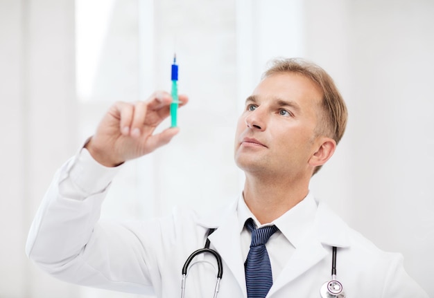 здравоохранение и медицинская концепция - врач-мужчина держит шприц с инъекцией